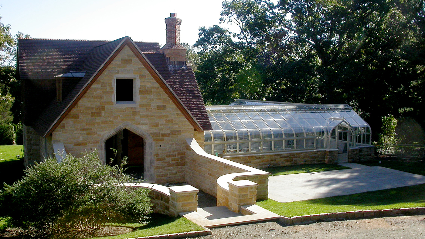 Curved eave double pitch greenhouse featuring ridge cresting, finials, and dormers