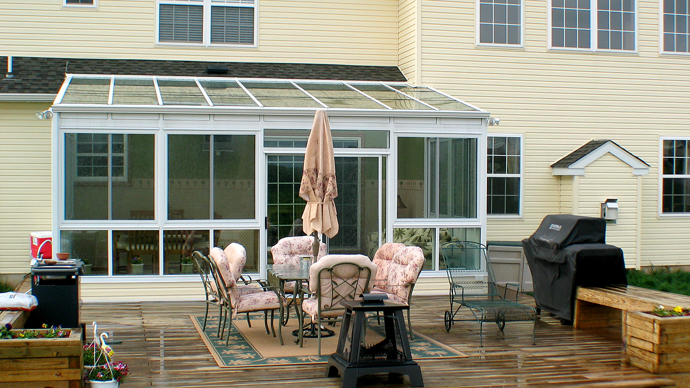 Straight eave lean to sunroom with sliding doors and windows
