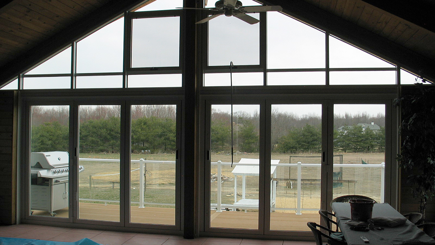 Aluminum curtain wall with integrated pole-operated awning windows and bifold doors.