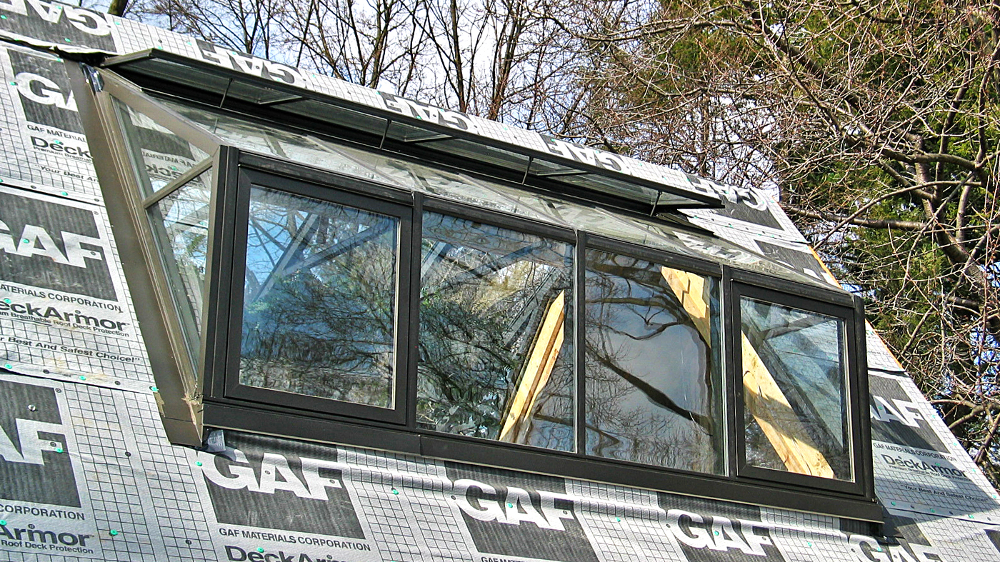 Straight eave lean-to greenhouse with 2 partial gable ends.