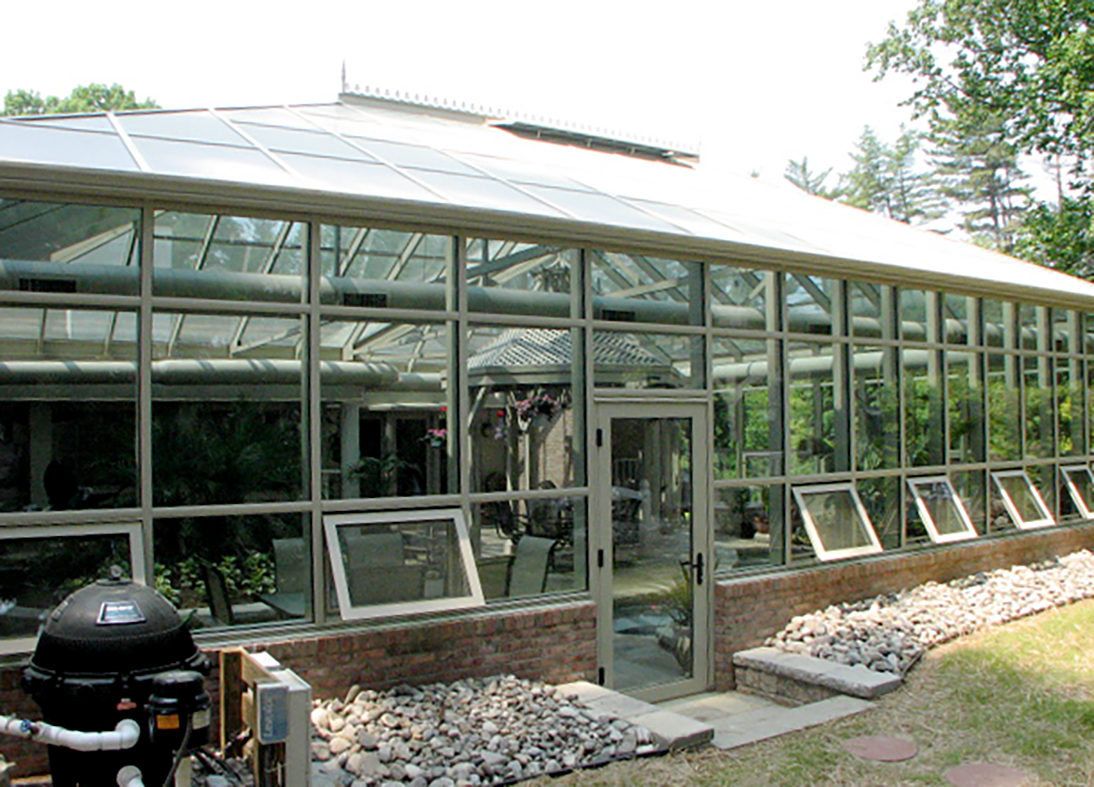 Straight-eave double pitch pool enclosure with two hip ends, one irregular hip corner, two full sidewalls, and one partial end wall. Unit includes awning windows, ridge cresting, finial and terrace door.