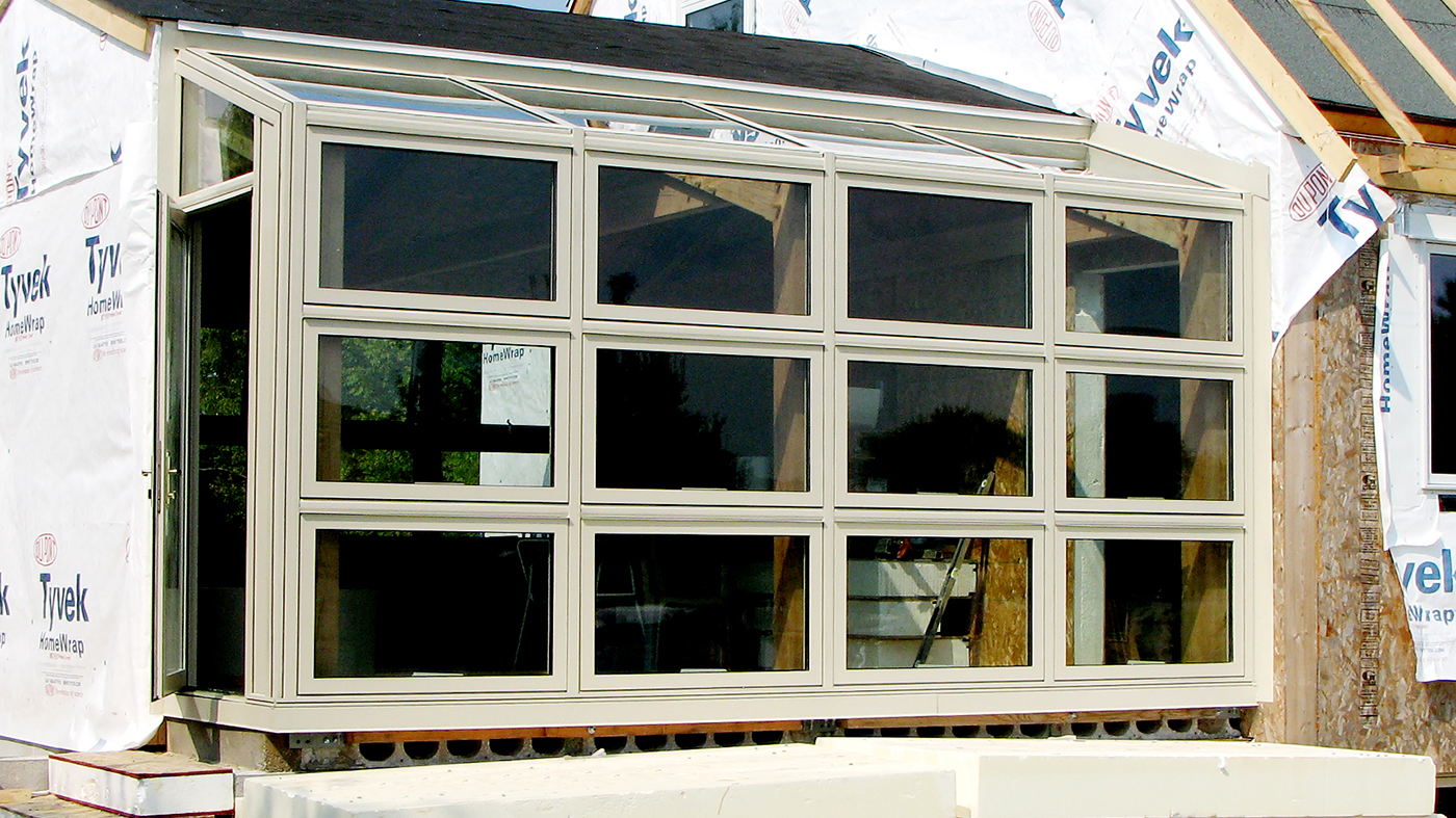 Straight eave lean-to sunroom and curtain wall with integrated awning windows