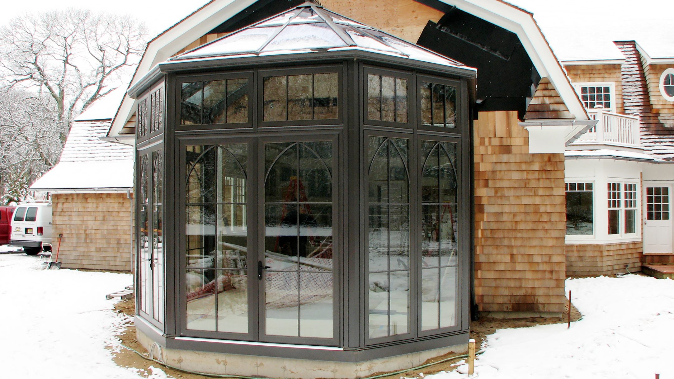 Straight eave double pitch pool enclosure with one conservatory nose, French doors, ridge vents, gridwork, gutter and downspout.