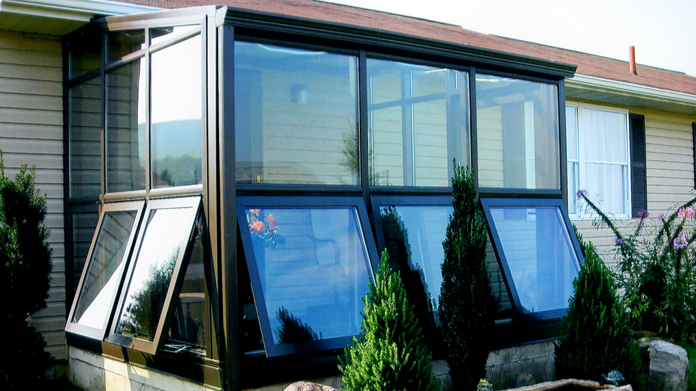 Straight eave lean-to sunroom with terrace door, awning windows, and gutter.