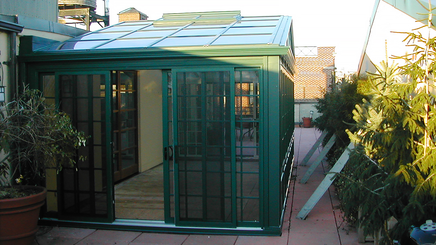 Straight eave double pitch greenhouse with decorative corner post; exterior is standard hartford green duracron and interior is standard white duracron. Unit has operable ridge vents, fixed windows, casement windows, and multi-track sliding/stack.