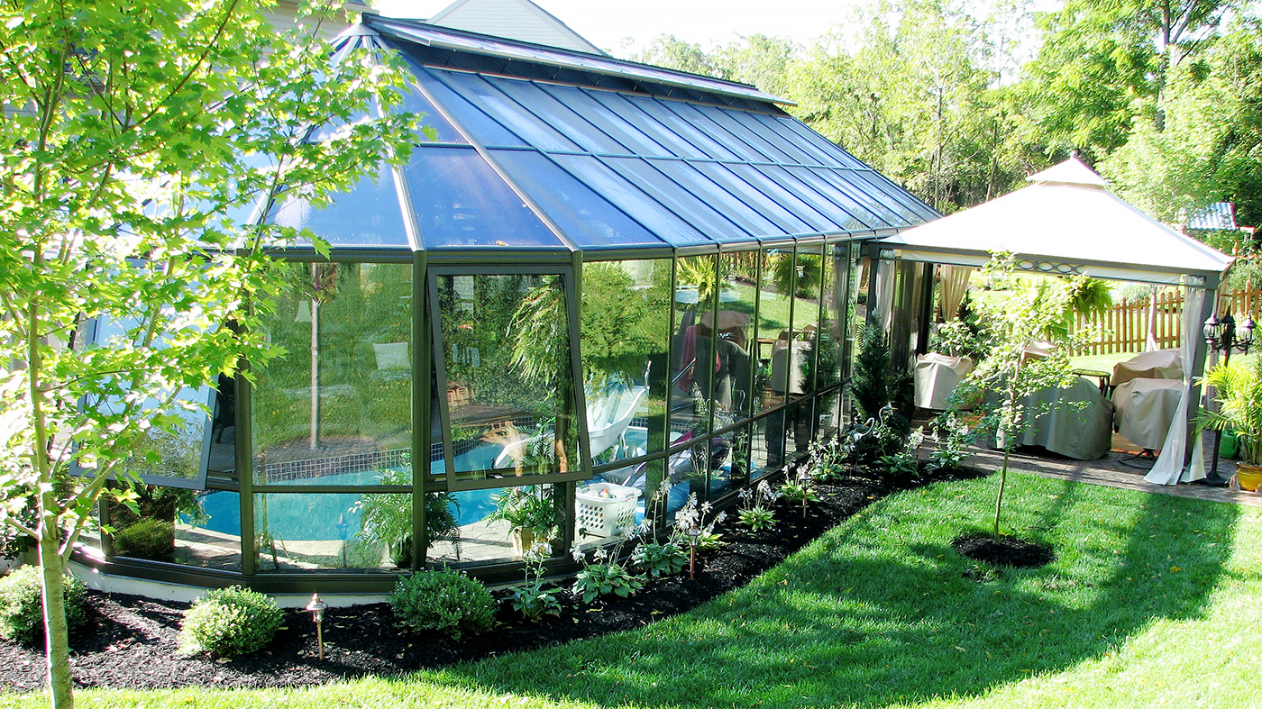 A straight eave double pitch pool enclosure with two conservatory noses and one straight eave double pitch walkway. Uses 4 1/2 and 7 inch aluminum systems, has awning windows, operable ridge vents, and a sliding glass door.
