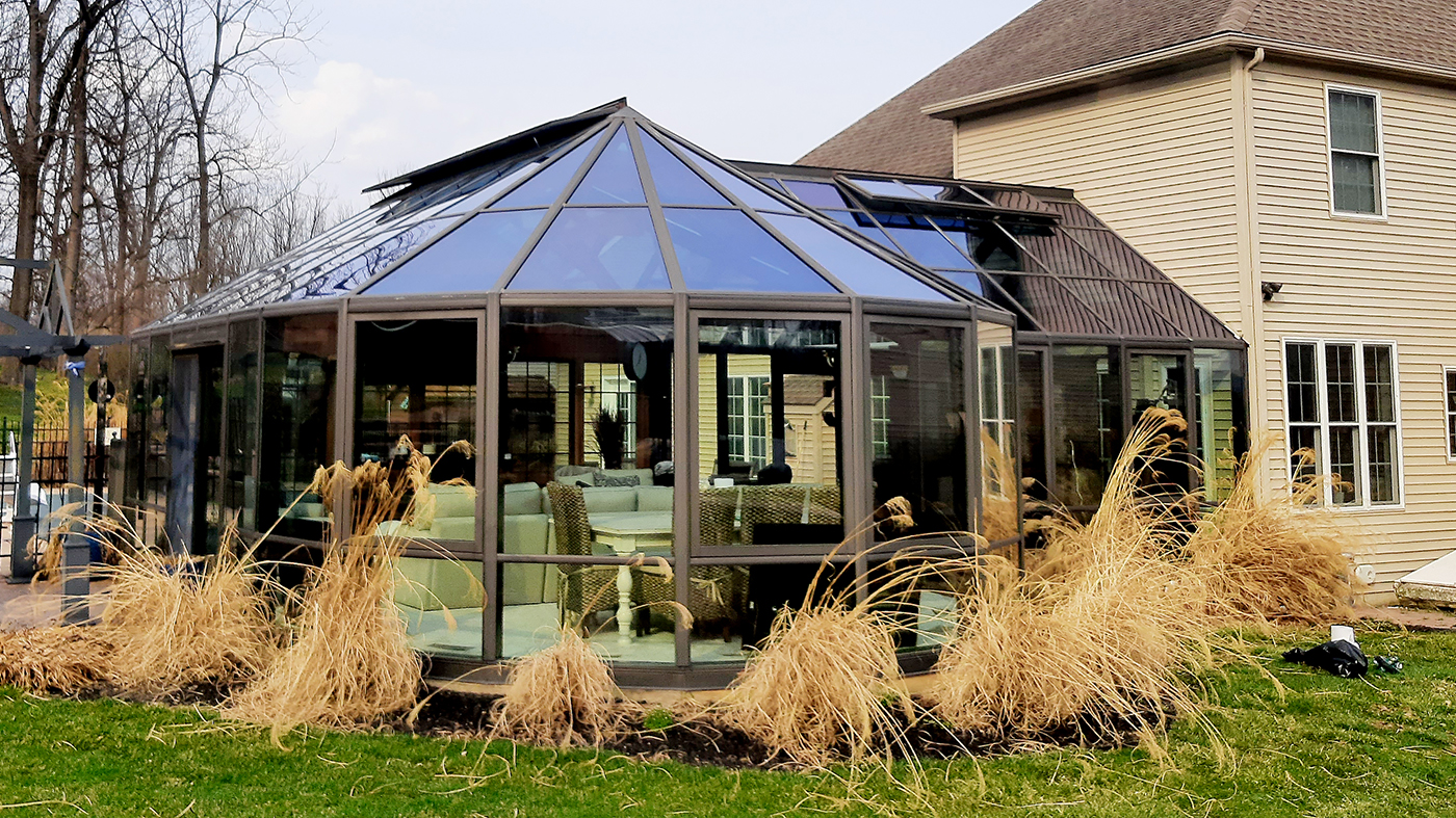 A straight eave double pitch pool enclosure with two conservatory noses and one straight eave double pitch walkway. Uses 4 1/2 and 7 inch aluminum systems, has eight awning windows, operable ridge vents, two terrace doors and three two-panel (XO & OX configurations) dual-track sliding glass door units.