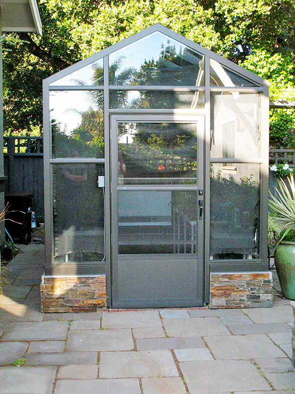 Straight eave, double pitch greenhouse with attached lean-to, operable ridge vent, awning windows and decorative raised base panels.