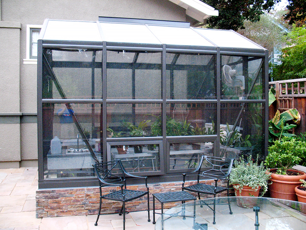 Straight eave, double pitch greenhouse with attached lean-to, operable ridge vent, awning windows and decorative raised base panels.