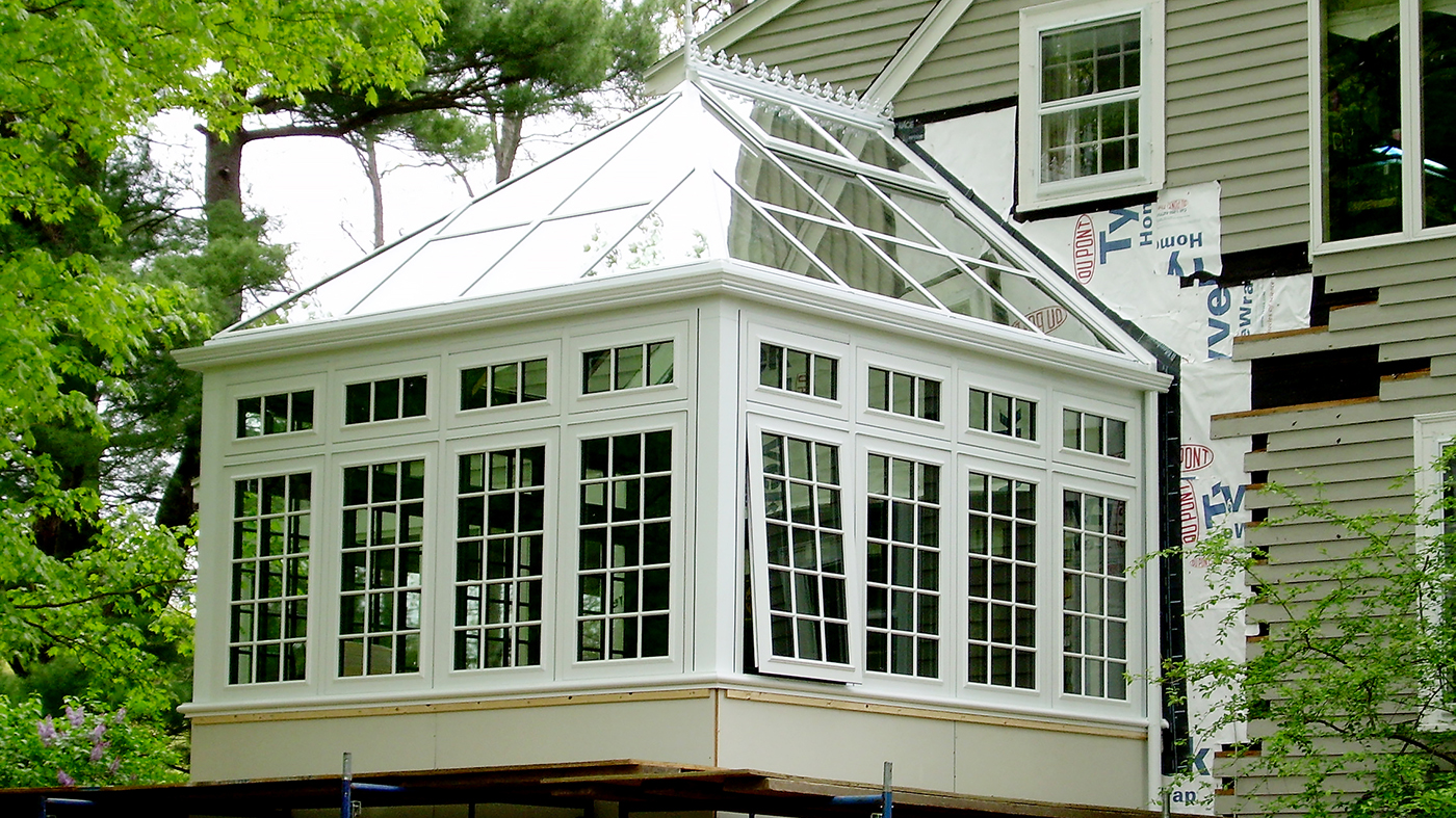 Straight eave double pitch conservatory with one hip end. Decorative accessories include: ridge cresting, finial, SDL grids in traditional pattern, transoms, fixed windows and ogee capping.