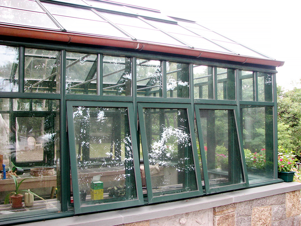 Straight Eave double pitch hobby greenhouse with one gable end, copper gutter, transoms, awning windows, and ridge vents.
