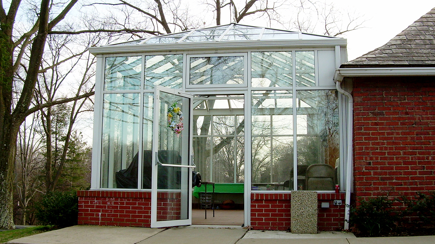 Straight eave, hip end conservatory with transoms, ridge cresting, and finials.