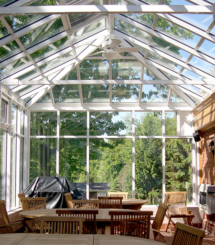 Straight eave, hip end conservatory with transoms, ridge cresting, and finials.