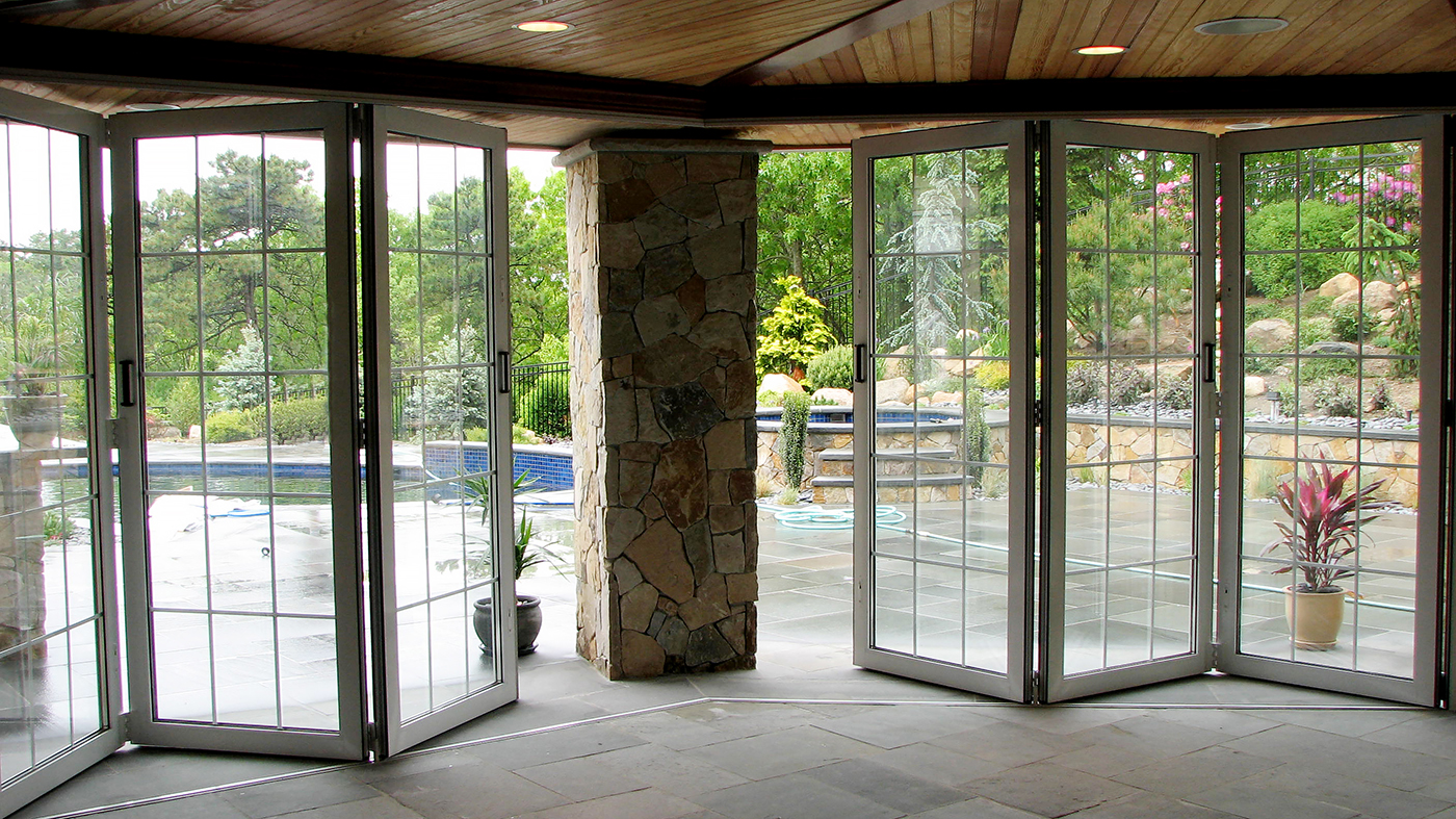 five all wall folding door systems with panels that fold to the interior which feature interior muntin gridwork, and a recessed sill with flush stop