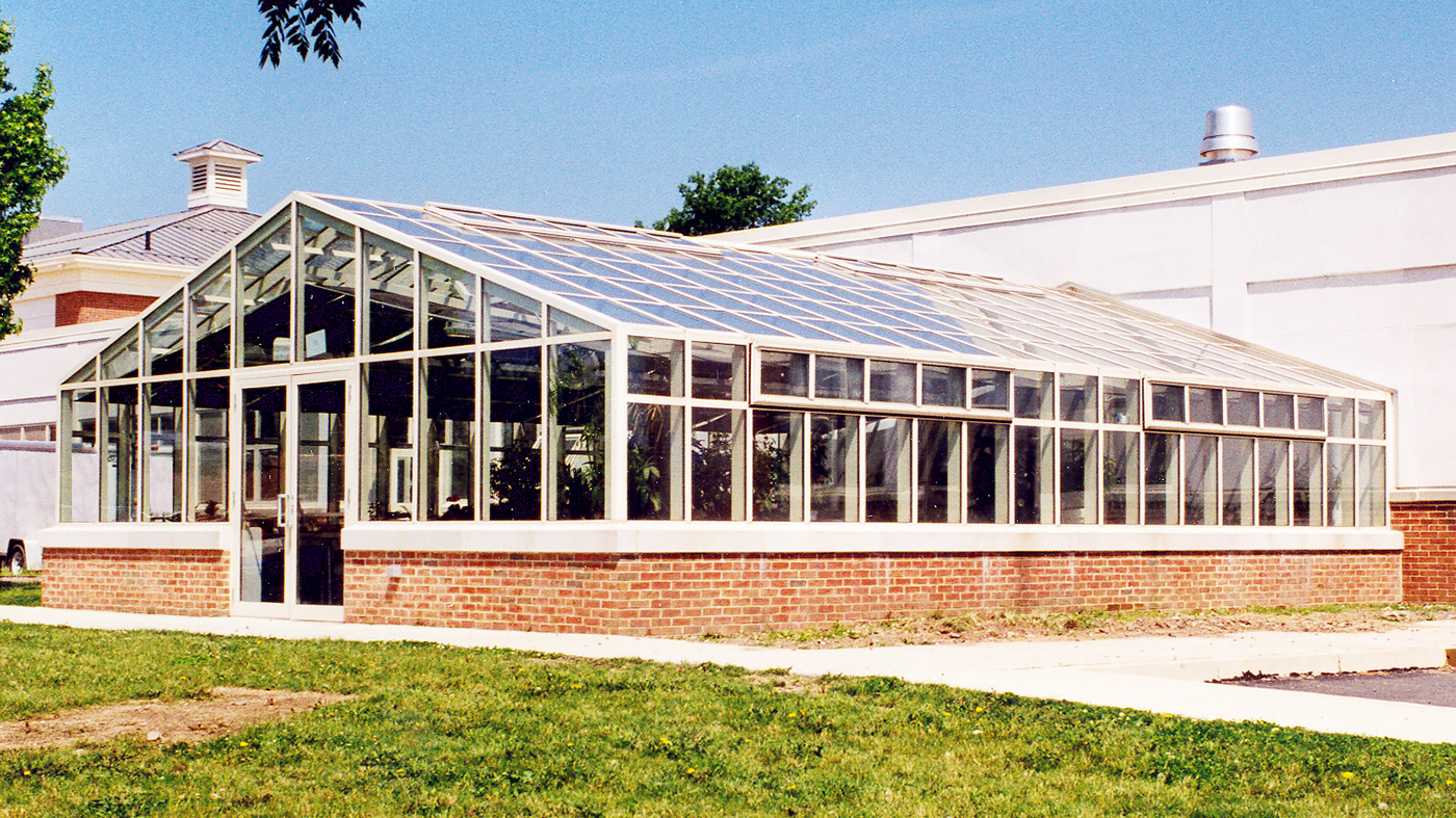 Straight eave double pitch greenhouse with operable ridge and eave vents and interior operable shades.