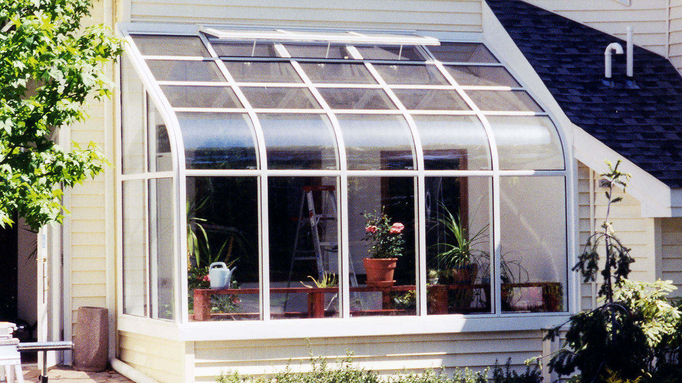 Curved eave, lean-to sunroom with operable ridge vent.
