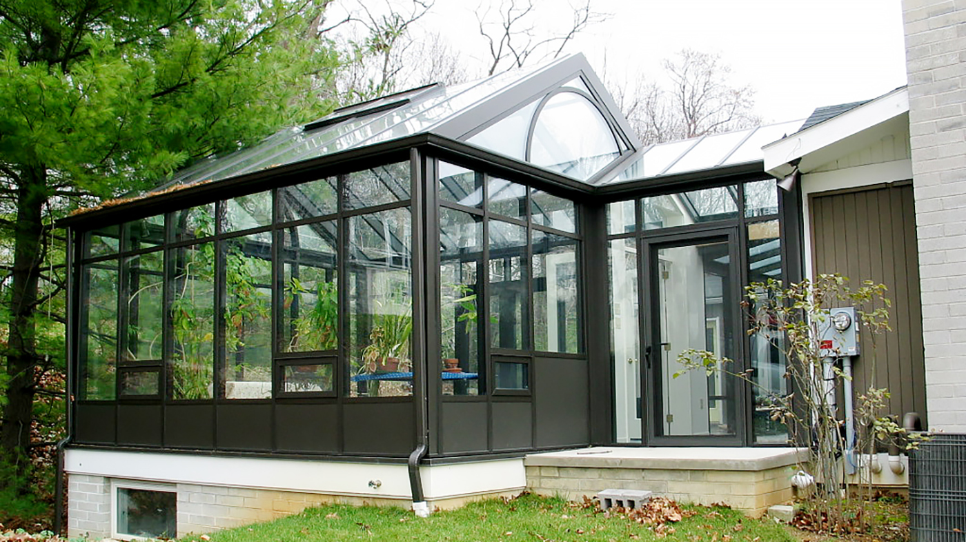 Custom Sunroom configuration: (1) straight eave double pitch and (1) straight eave lean-to Sunroom connected by an enclosed walkway. Decorative elements include: radius arch in gable end, solid base panel, gutter, and downspouts.