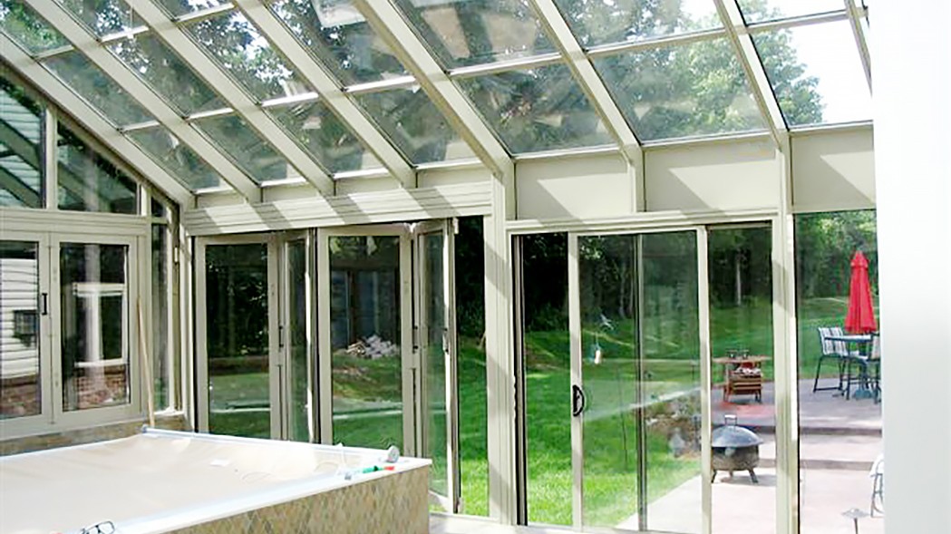 Straight eave double pitch pool enclosure with ridge vents, folding windows, a folding wall and a sliding door system.