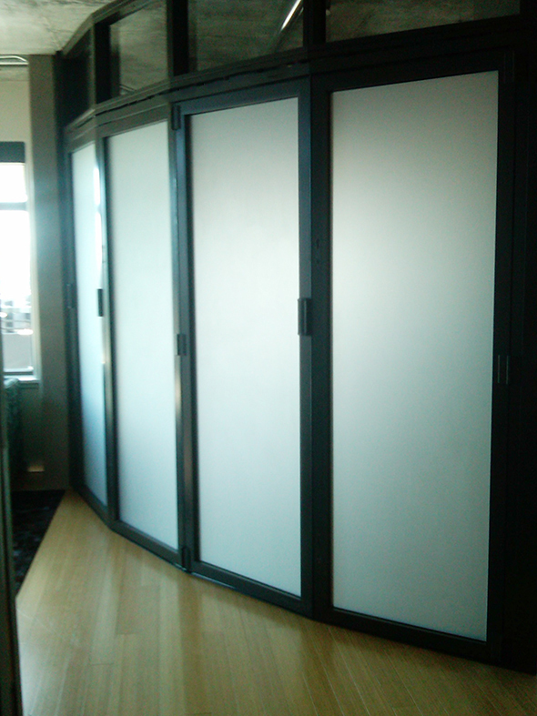 Two interior folding wall systems used on a residential application. One unit is an all wall segmented radius configuration with a segmented transom above and utilized a recessed sill. The second unit is a straight all wall configuration with a transom above and a flush mount sill.