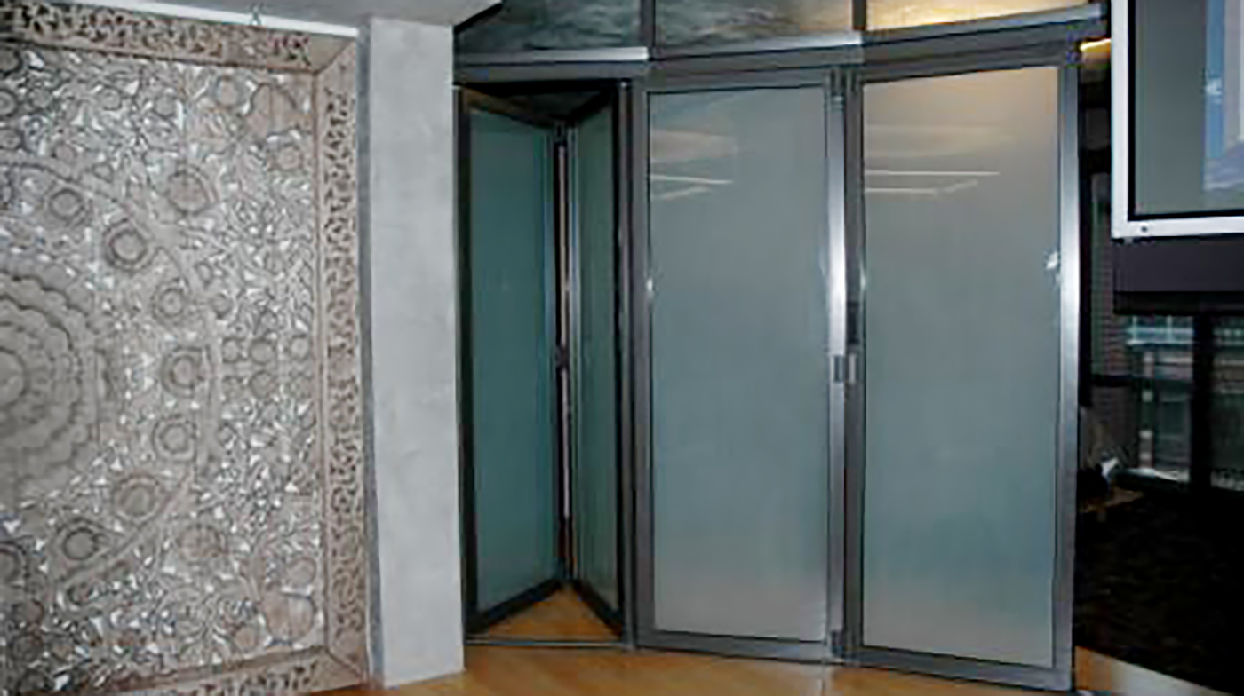 Two interior folding wall systems used on a residential application. One unit is an all wall segmented radius configuration with a segmented transom above and utilized a recessed sill. The second unit is a straight all wall configuration with a transom above and a flush mount sill.
