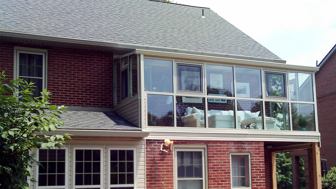 Straight eave lean-to sunroom with two gable ends, located on a second story application, with tilt turn windows and a ridge vent.