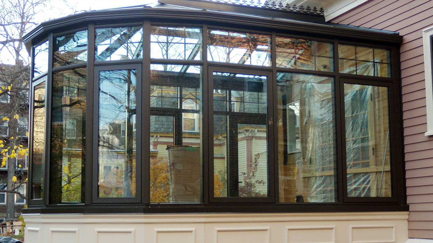 Transoms create a geometric pattern around the top of the 8-panel nose of this conservatory. Other decorative elements include ridge vents, ridge cresting, finials, and interior muntins.