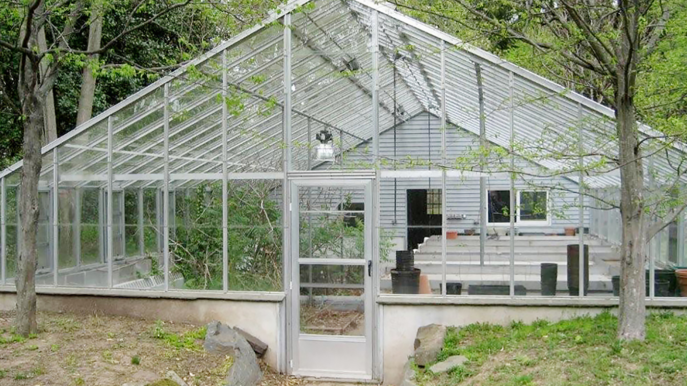 Existing greenhouse with retrofits by Solar Innovations. Additions include an operable, roof mounted shade system, humidifiers, ridge vent replacement, and fixed mesh top benches.P