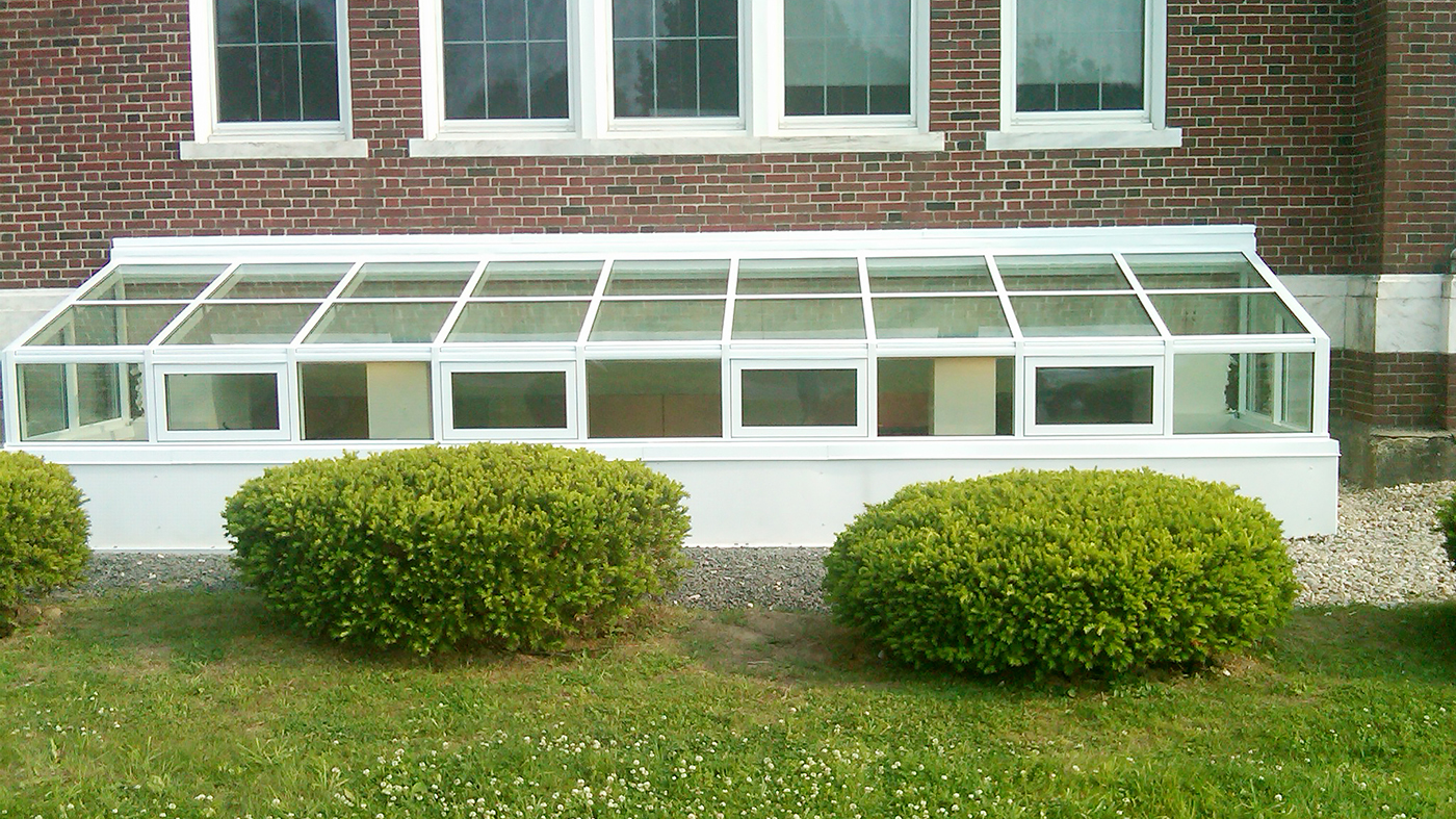 Two straight eave lean-to window well covers with gable ends.
