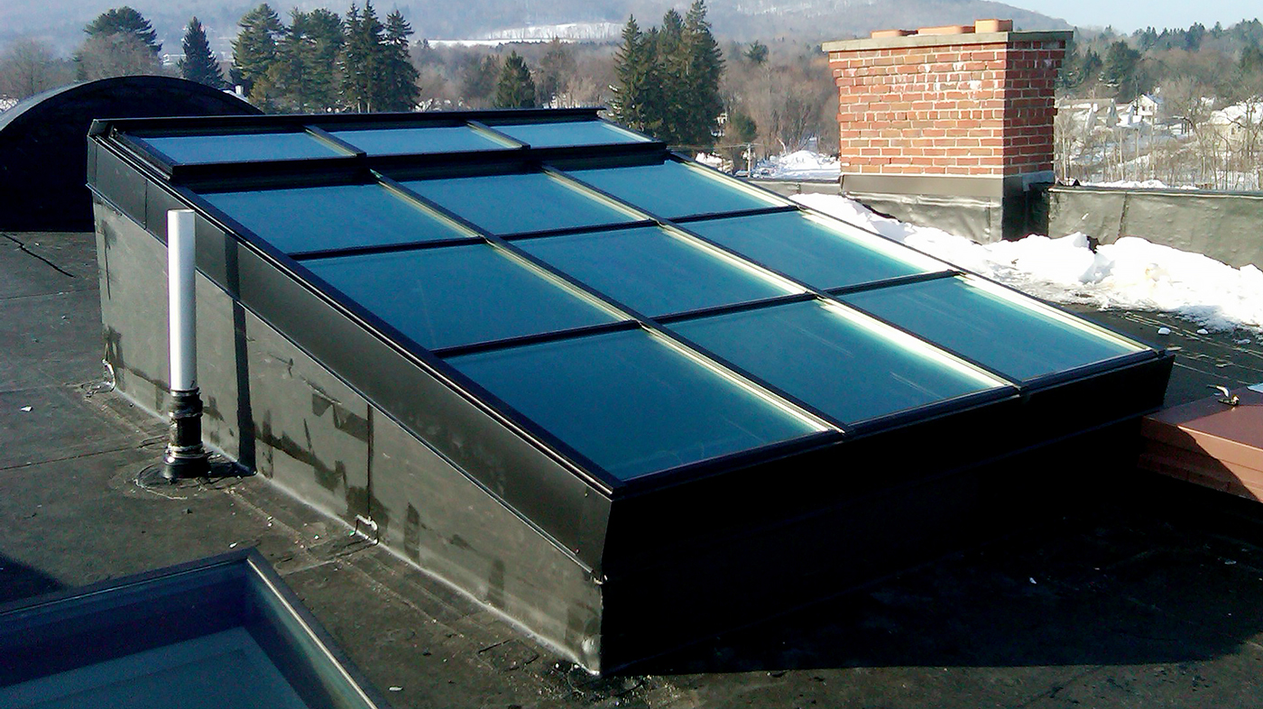 Curb mounted flat skylight with operable ridge vents