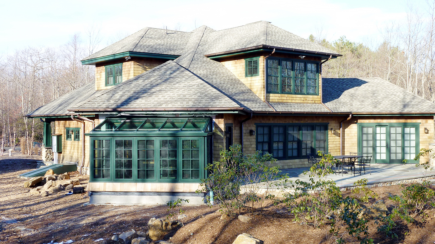 Straight eave lean-to sunroom with two gable ends, casement windows, and decorative elements including transom, gutter, and downspout.