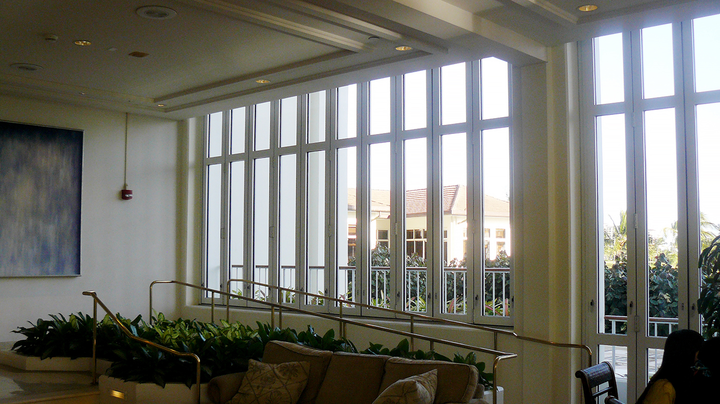 Multiple folding glass wall units used on a hotel including a center pivot folding wall with a split wall configuration and surface mount sill, sliding door and curtain wall, all with monolithic glazing.