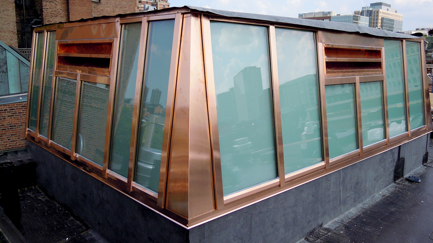   Lean-to skylight enclosing elevator shaft featuring Copper cladding exterior and white laminated glazing.
