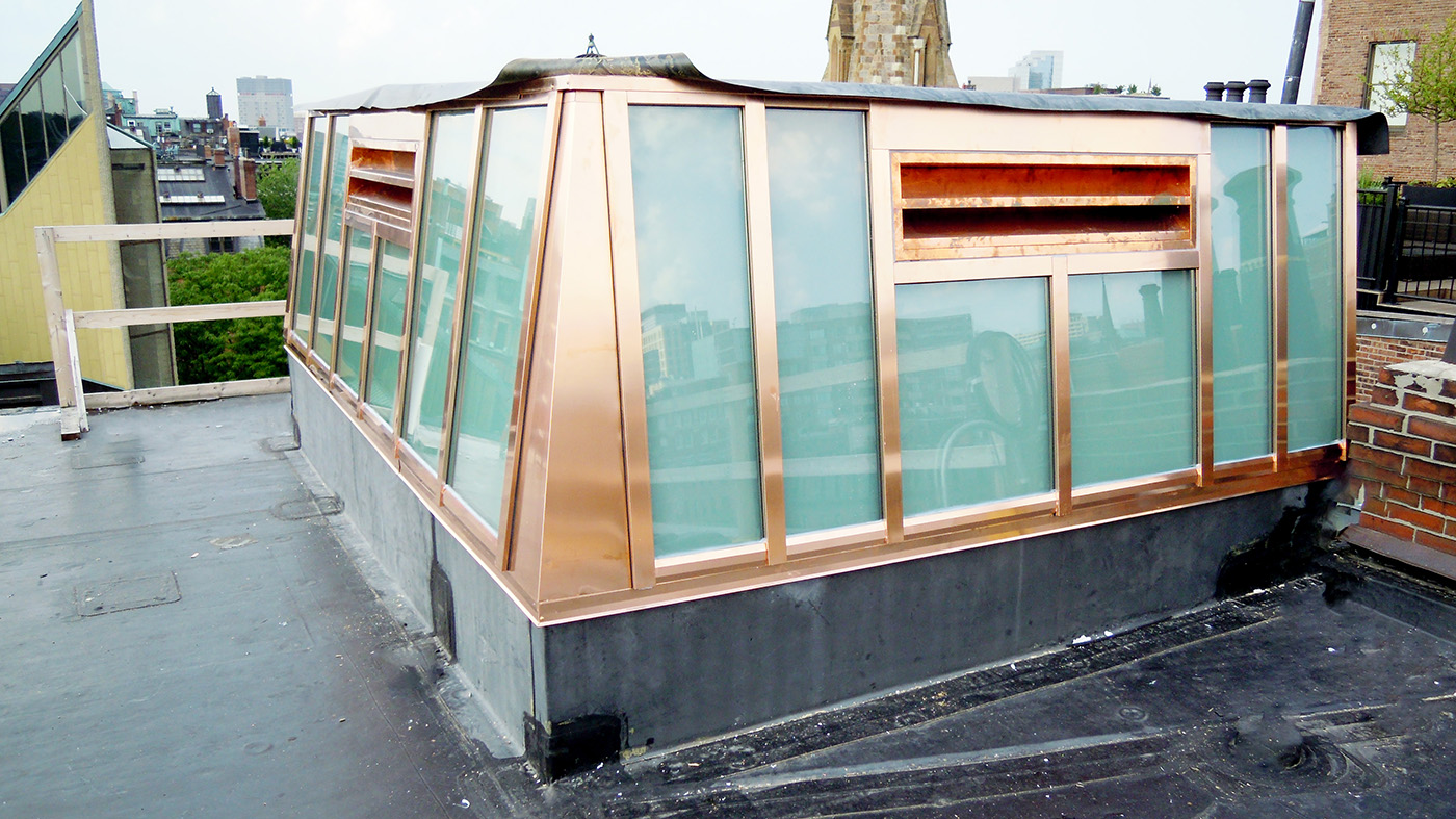   Lean-to skylight enclosing elevator shaft featuring Copper cladding exterior and white laminated glazing.