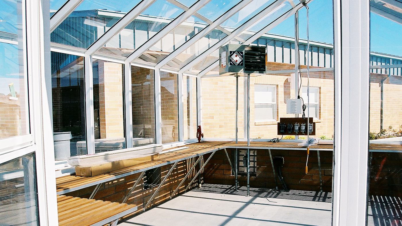 Straight eave, double pitch greenhouse with operable ridge vent and in-system terrace door.