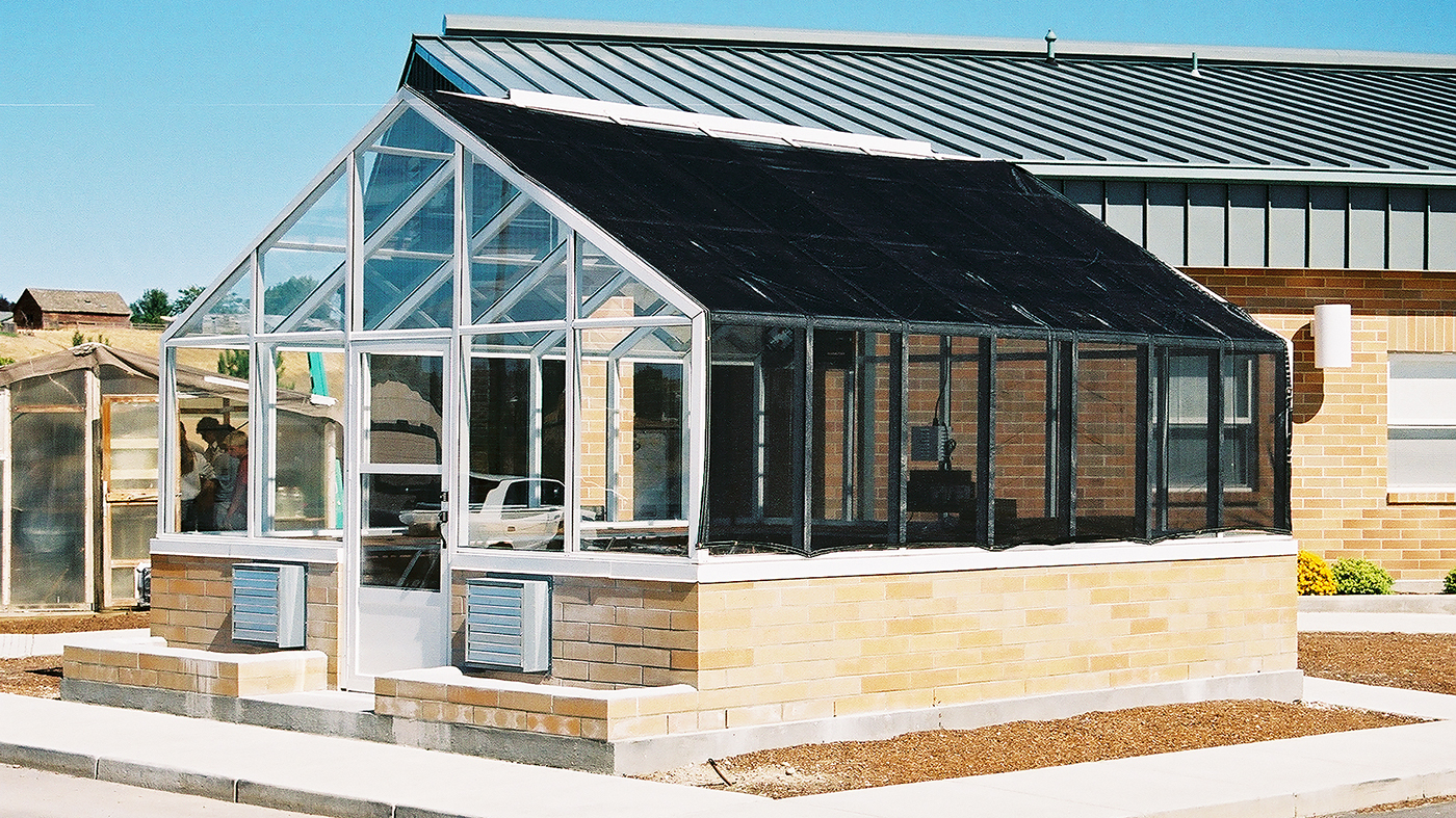 Straight eave, double pitch greenhouse with operable ridge vent and in-system terrace door.