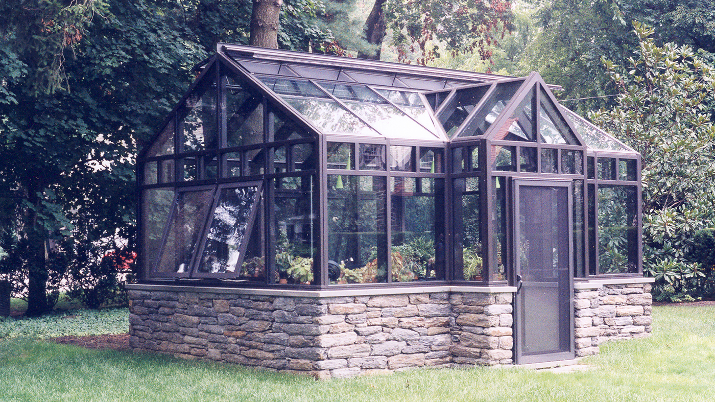Straight eave double pitch greenhouse with projected dormer, projected windows, ridge vents, and terrace door.