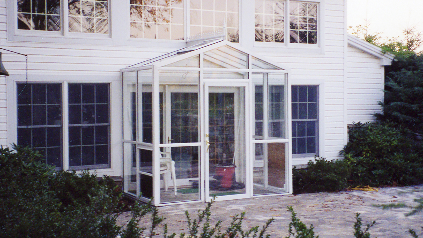 Straight Eave double pitch sunroom with one gable end. Features a terrace door, awning windows, a finial, and ridge cresting