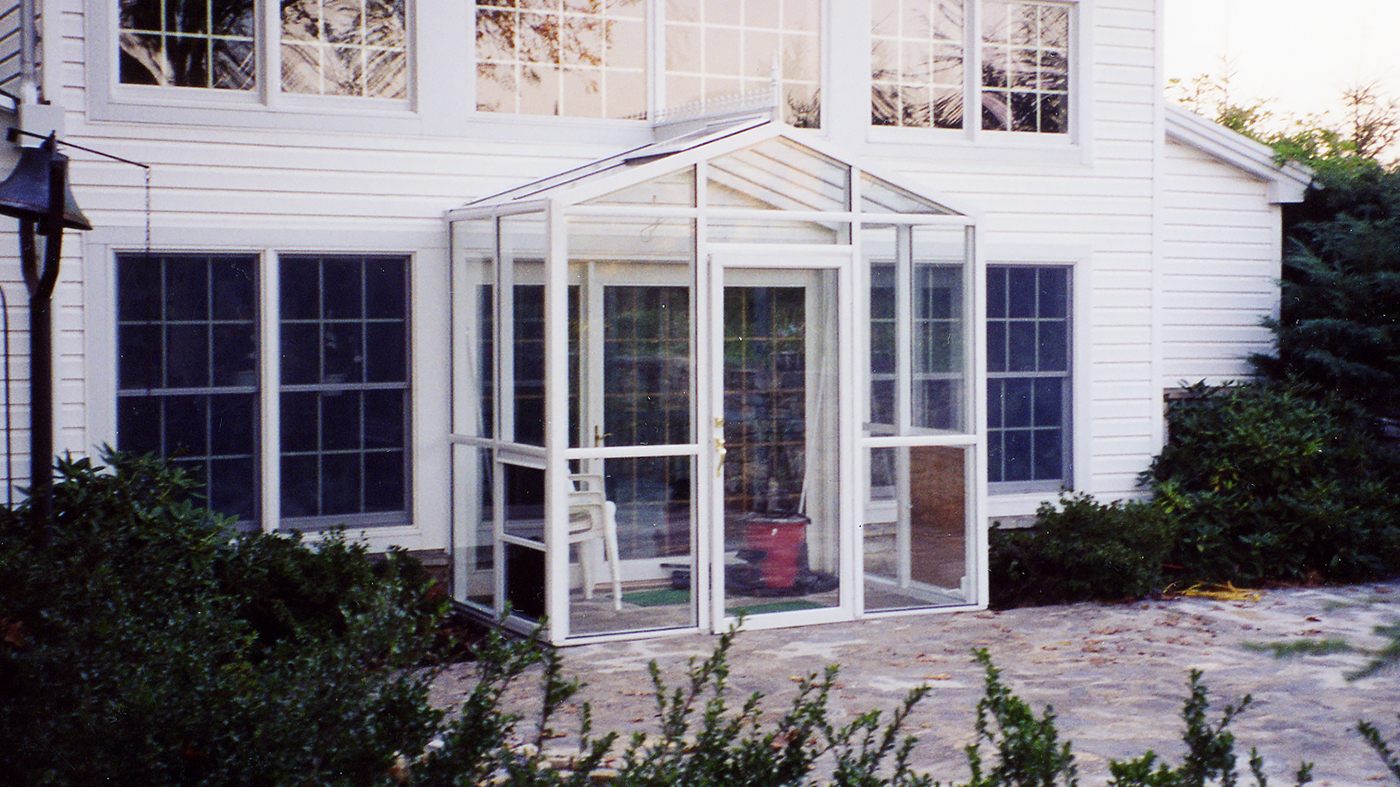 Straight Eave double pitch sunroom with one gable end. Features a terrace door, awning windows, a finial, and ridge cresting