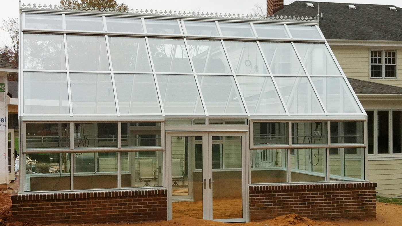 Straight eave double pitch greenhouse with two gable ends, ridge vents, eave vents, finial, ridge cresting, and French doors