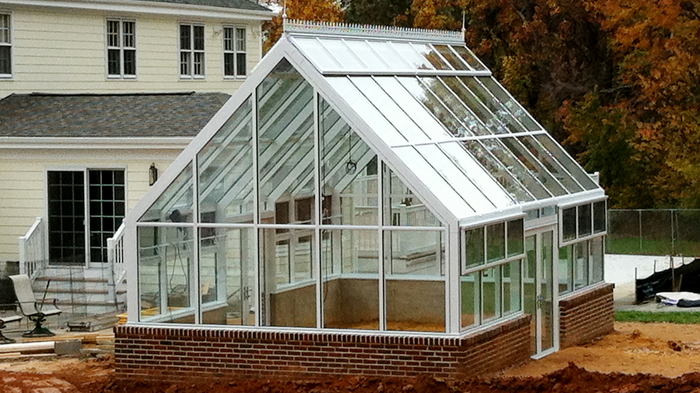 Straight eave double pitch greenhouse with two gable ends, ridge vents, eave vents, finial, ridge cresting, and French doors