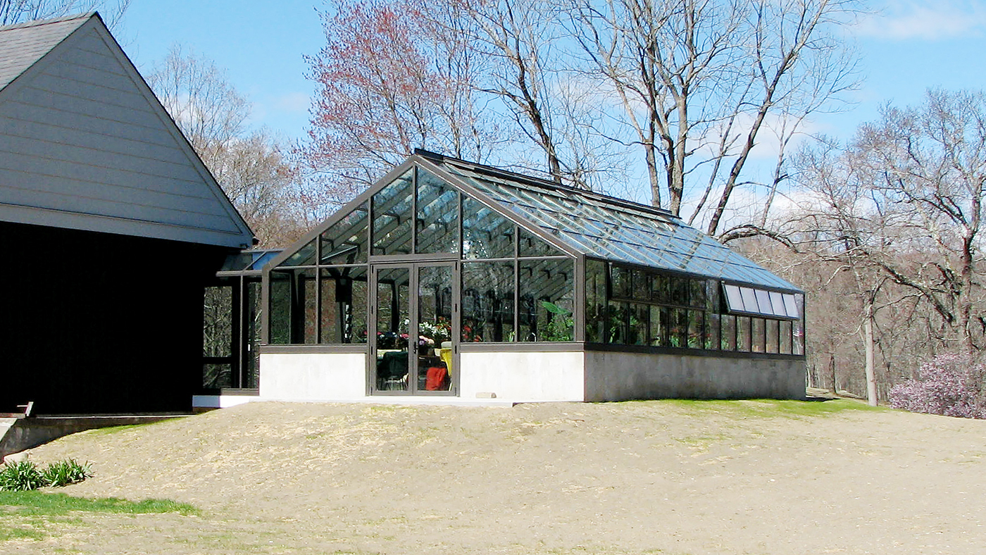 Straight eave double pitch greenhouse with two gable ends, attached double pitch walkway, French doors, ridge vents and eave vents, and decorative elements.