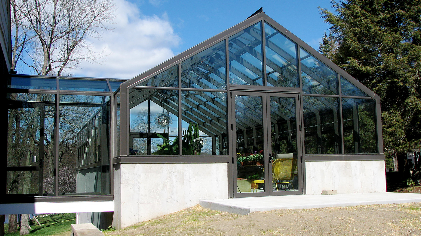 Straight eave double pitch greenhouse with two gable ends, attached double pitch walkway, French doors, ridge vents and eave vents, and decorative elements.