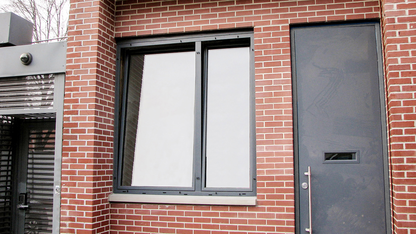 Double tilt turn window with fixed astragal using the European window system and a three-panel folding glass wall system with obscure #62 acid etch glass.