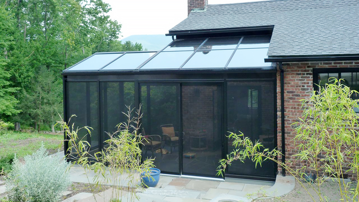 Irregular straight eave double pitch screened-in sunroom with a straight leave lean-to section, glass roof, specialty pet screen walls and sliding doors