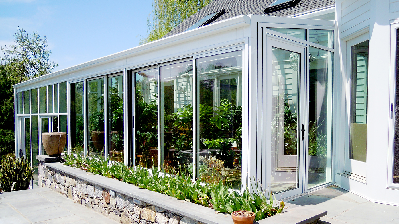 Straight eave lean to greenhouse with two gable ends, ridge vents, eave vents, terrace door, sliding door, heater, circulation fan and aluminum tube plant hanger.