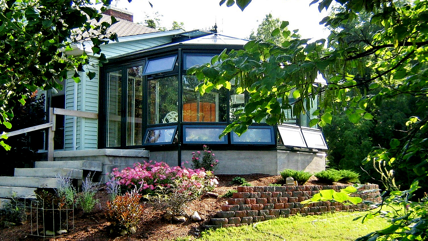  A straight eave double pitch conservatory with one conservatory nose, awning windows, ridge vents, finial, ridge cresting, gutter and downspout.