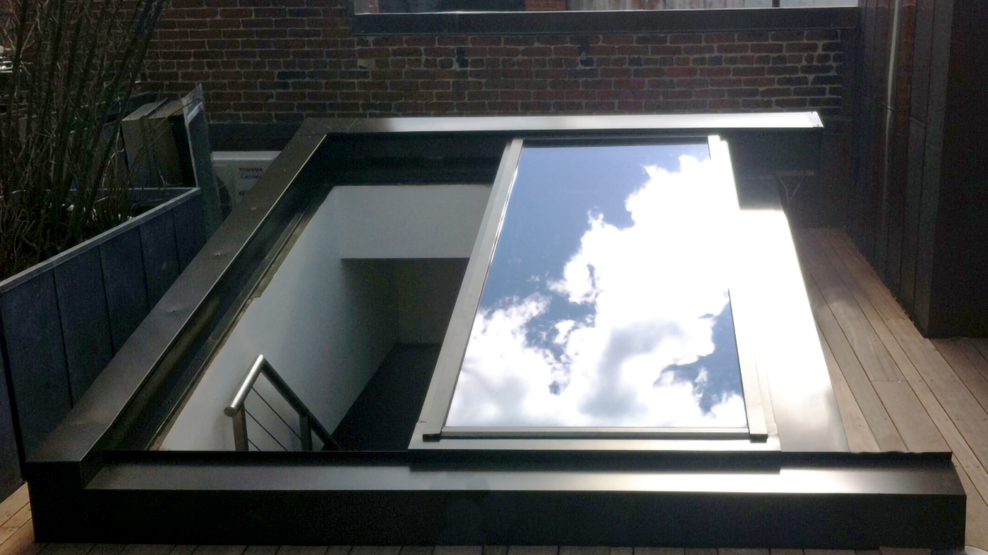 Skylight custom designed to a single slope retractable provided natural ventilation for a residence in an urban neighborhood with limited options.. The weather sensor recognizes wind speed and rain, triggering the motorized operator to automatically close the skylight when the conditions are no longer optimal. 