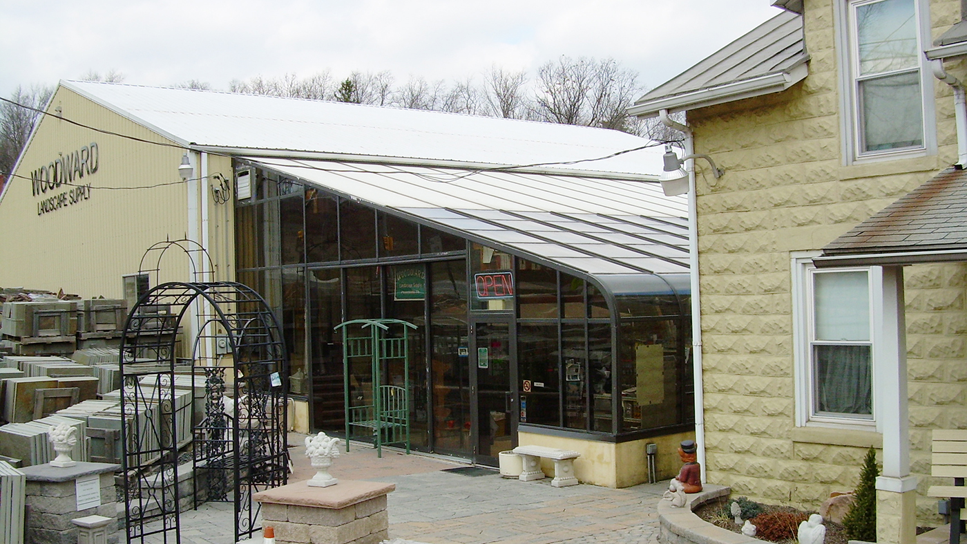 Curved eave lean-to greenhouse in this commercial end building supply store.