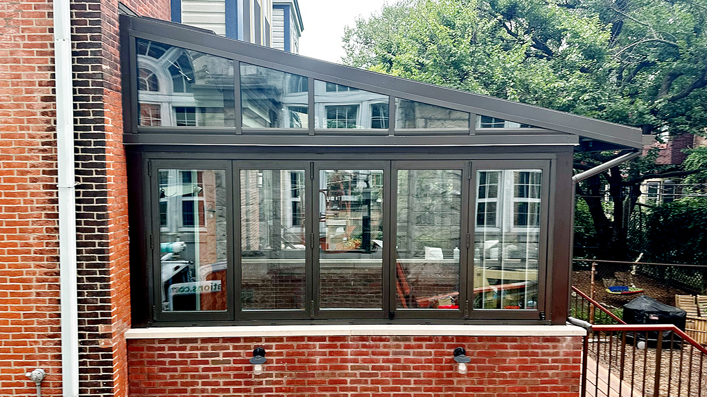 Straight eave lean-to sunroom/skylight with two 5-panel G2 outfold all-wall bifold window units and one four-panel G2 outfold  single door hinged jamb (SDHJ) bifold door unit incorporated into the design.