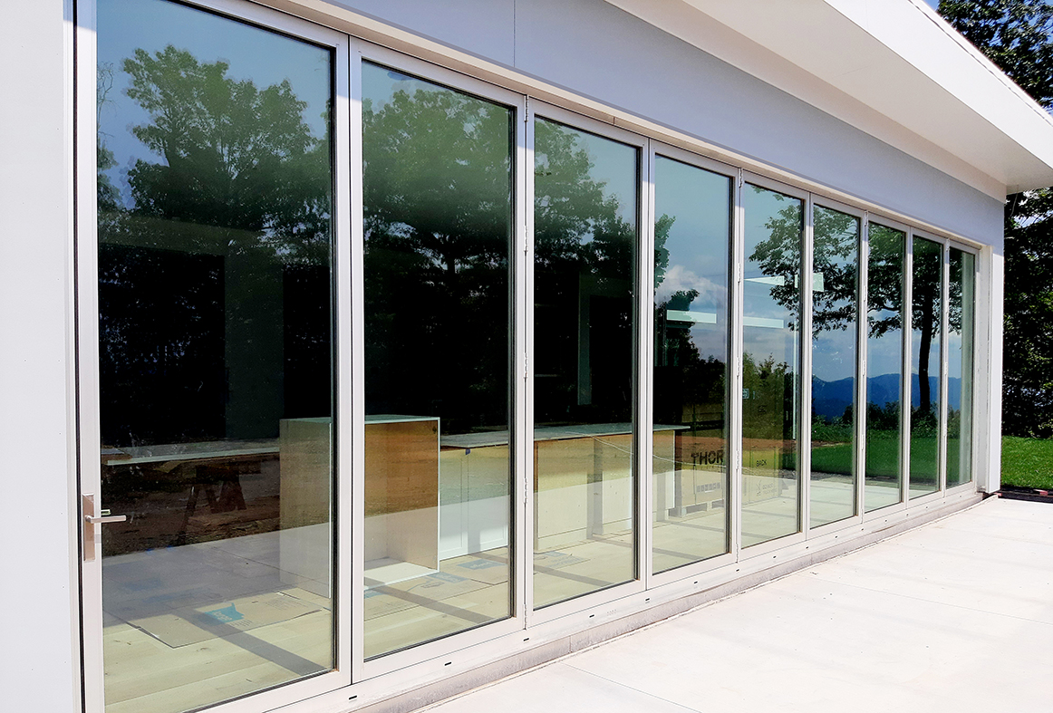 One nine-panel all-wall bifold door unit (pictured), three four-panel, one three-panel, five two-panel all-wall bifold door units, and one four-panel slide and stack clear glass wall unit.